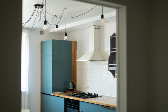 Modern Kitchen with Blue Cabinets and Pendant Lighting
