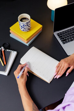 Woman Writing in Planner at Modern Desk