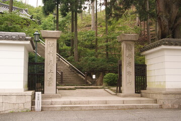 緑豊かな杉林と石造りの寺院門