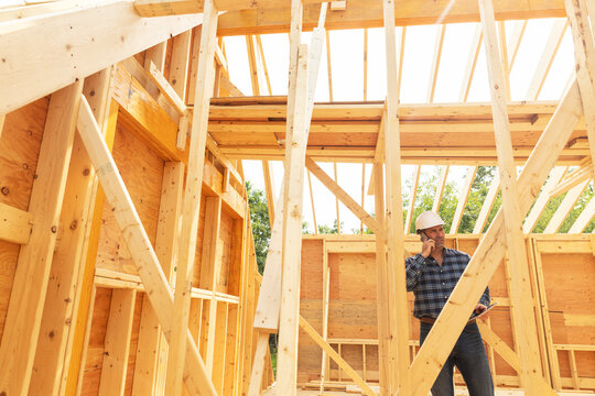 Worker talking on cell phone construction 