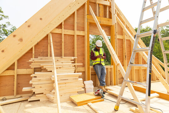 Construction worker taking break texting on cell phone 