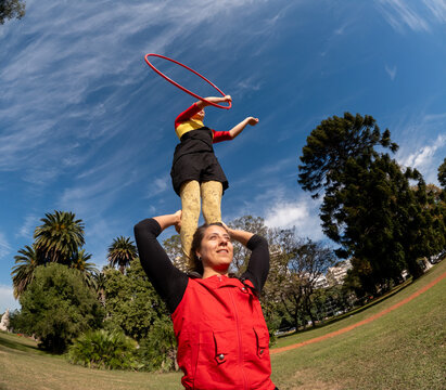 Skillful Performer Balances Dancer While Spinning Hoop Outdoors