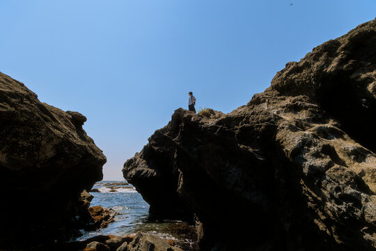 A woman gazing into the distance from a rocky cliff.