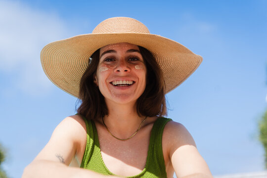 Happy woman wearing sunhat outdoors