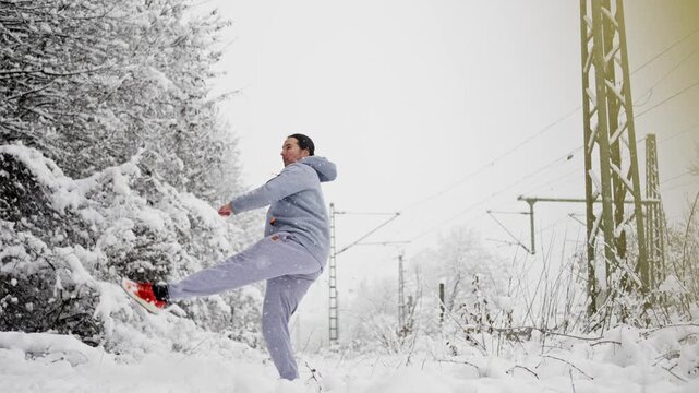 Quick Stepping Back Followed By Forceful Kick. Man Swiftly Moves Away And Unleashes Vigorous Snow Kick. Individual Promptly Retreats And Then Executes Forceful Kick Towards Snow Surface