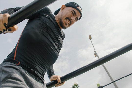 Man performs dips at outdoor fitness park during daytime