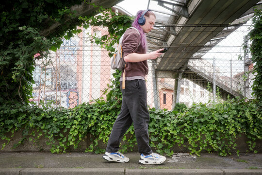 Young Person Walking With Headphones in an Urban Environment
