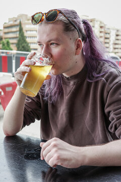 Person Enjoying a Drink at an Outdoor Cafe in the Afternoon
