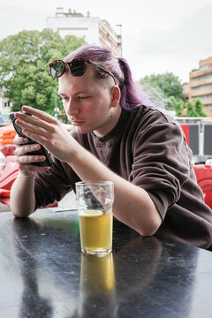 A guy Enjoying a Drink and Texting on a Smartphone 