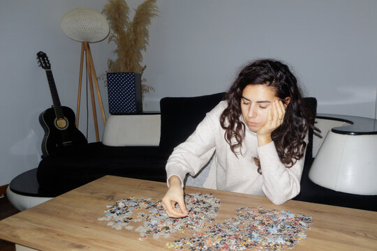A young woman is putting together a puzzle