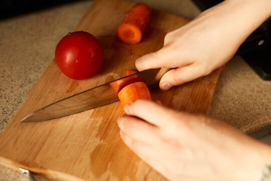 Woman chops carrot, detail