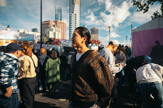 Asian Man at a Busy Street Market in Federation Square