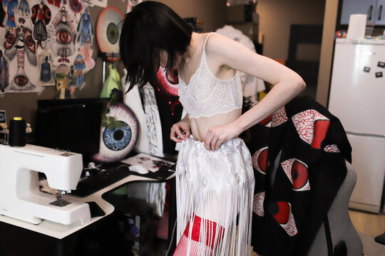 A woman changes clothes in a room. 