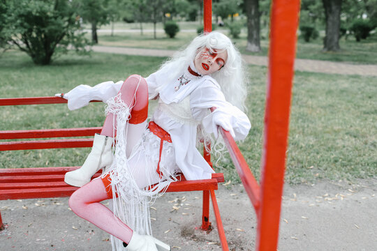 A woman in a wig and a bright costume walks through the city