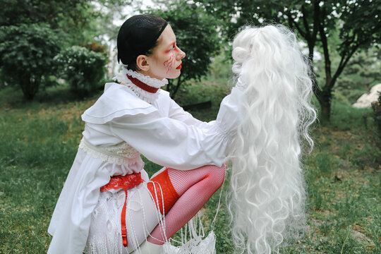 a woman holds a wig in her hands
