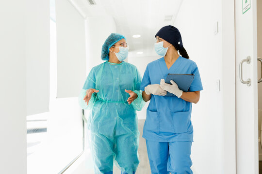 Medical staff walking and talking in hospital corridor