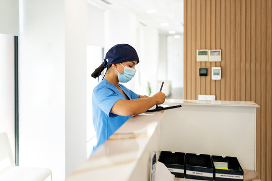 Nurse writing on a tablet at the reception of a modern dental clinic