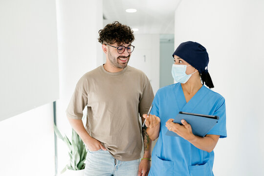 Nurse wearing surgical mask explaining medical procedure to patient