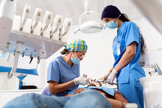 Dentist and assistant performing dental procedure on patient