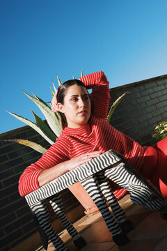Modern outdoor lounge with woman in striped outfit at sunset