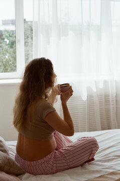 Pregnant woman having tea at home