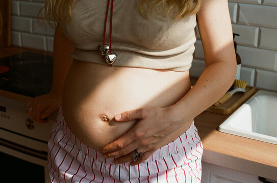 Pregnant woman gently touching her baby bump