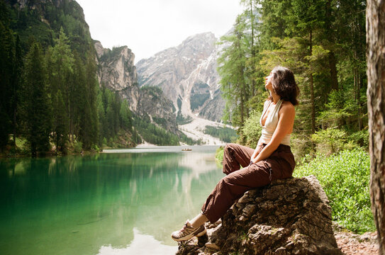 Woman on rock by turquoise lake in the Dolomites, shot on film

