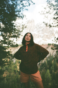 Woman in leopard sweater standing against snowy mountain backdrop

