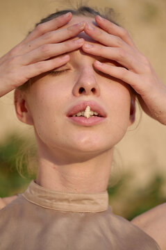 Close-up portrait of woman with a seashell between her lips