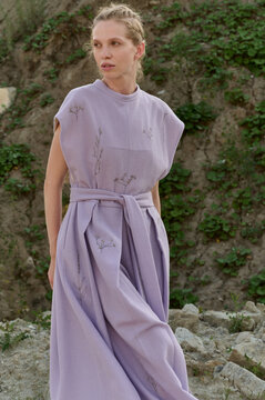 Elegant woman in lilac dress posing outdoors