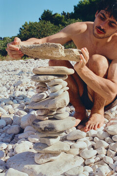Man building a stone tower in the beach 