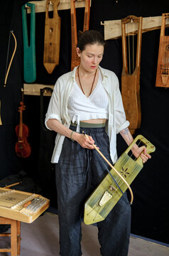 portrait of a woman in a workshop with musical instruments in the back