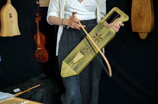 portrait of a woman in a workshop with musical instruments in the back