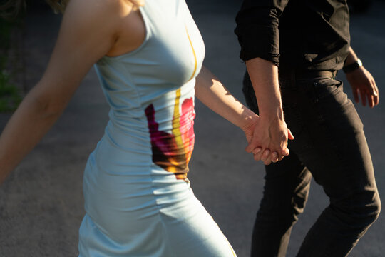 Couple Enjoying a Stroll Outdoors Holding Hands on a Sunny Day