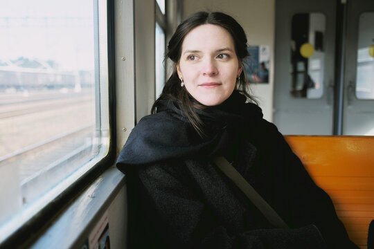 Girl in a vintage coat traveling on a train