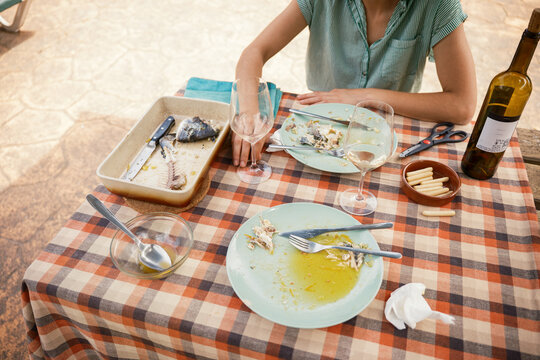 Sitting at table in front of dirty and empty dishes