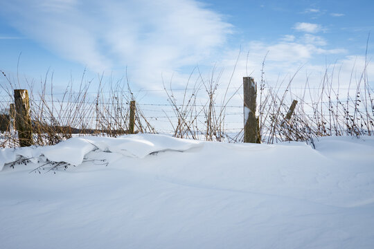 Winter auf dem Lande, eingeschneiter alter Stacheldrahtzaun einer Weide, Symbolfoto.