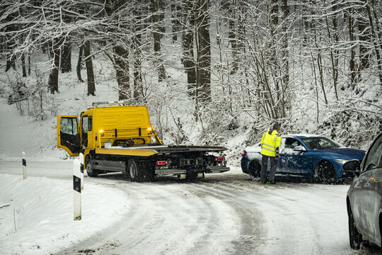 Wintereinbruch - Abschleppdienst bei der Bergung eines Unfallfahrzeuges auf einer vereisten Bergstrasse, Symbolfoto.