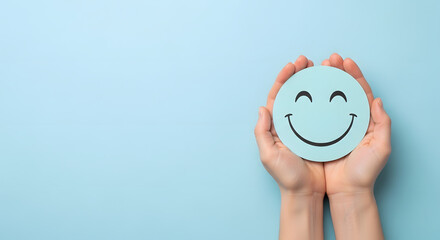 Fototapeta premium Hands holding a smiley face against a blue background.