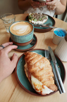 Enjoying Coffee and Croissant at a Cozy Caf&eacute; Setting