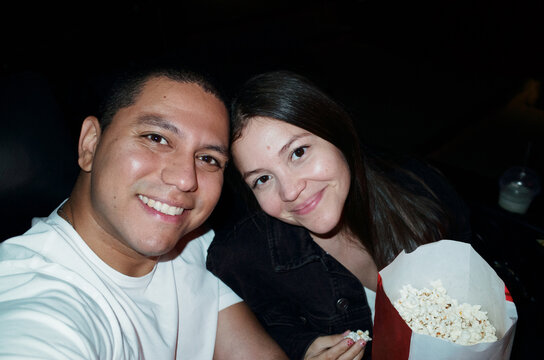 Couple Enjoys a Movie Night With Popcorn at a Theater