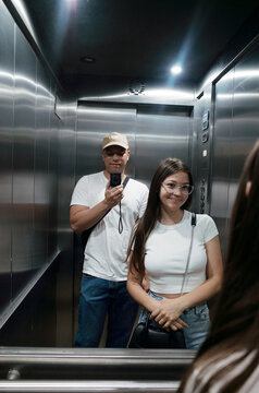 Couple Enjoying a Fun Moment in a Modern Elevator