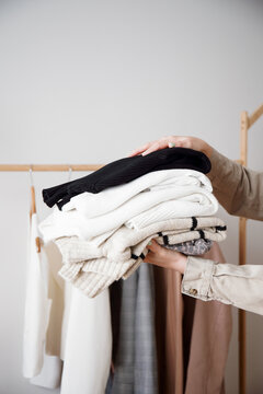 Organizing a Stack of Cozy Sweaters in a Clothing Store