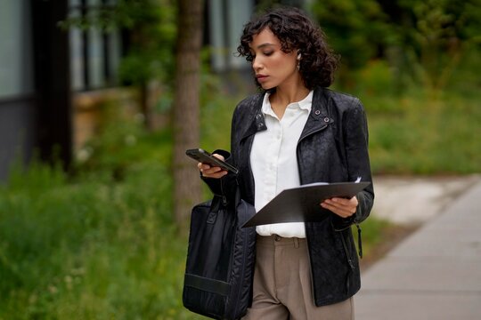 Professional Woman Walking Outside While Checking Her Phone