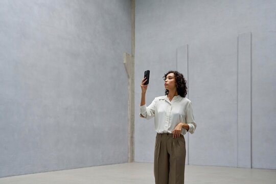 Woman Recording a Video in a Minimalist Indoor Space