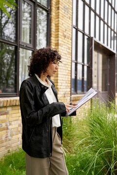 Professional woman reviewing documents outside an urban building
