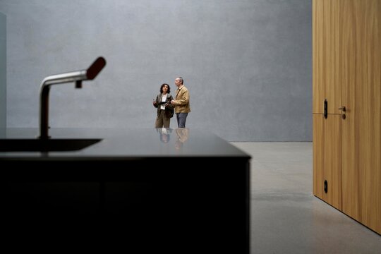 Couple Discussing Design Concepts in Modern Interior Setting 
