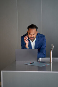 Professional man talking on phone while working in kitchen