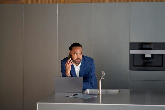 Businessman working from modern kitchen during evening