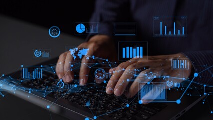 A close-up of hands typing on a keyboard with a futuristic digital data overlay. The image conveys...